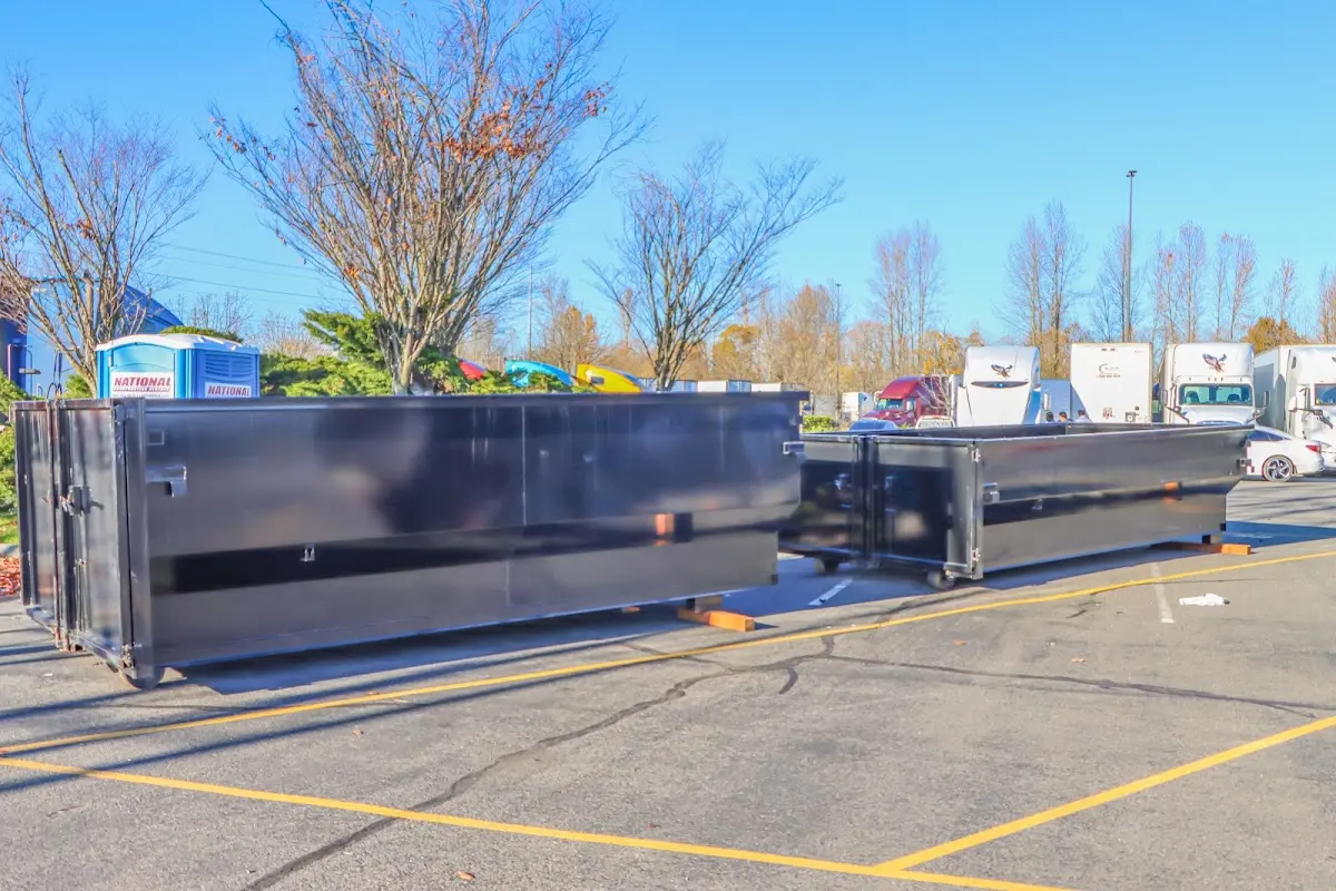 Professional dumpster rental service with roll-off container on residential driveway in Geneseo